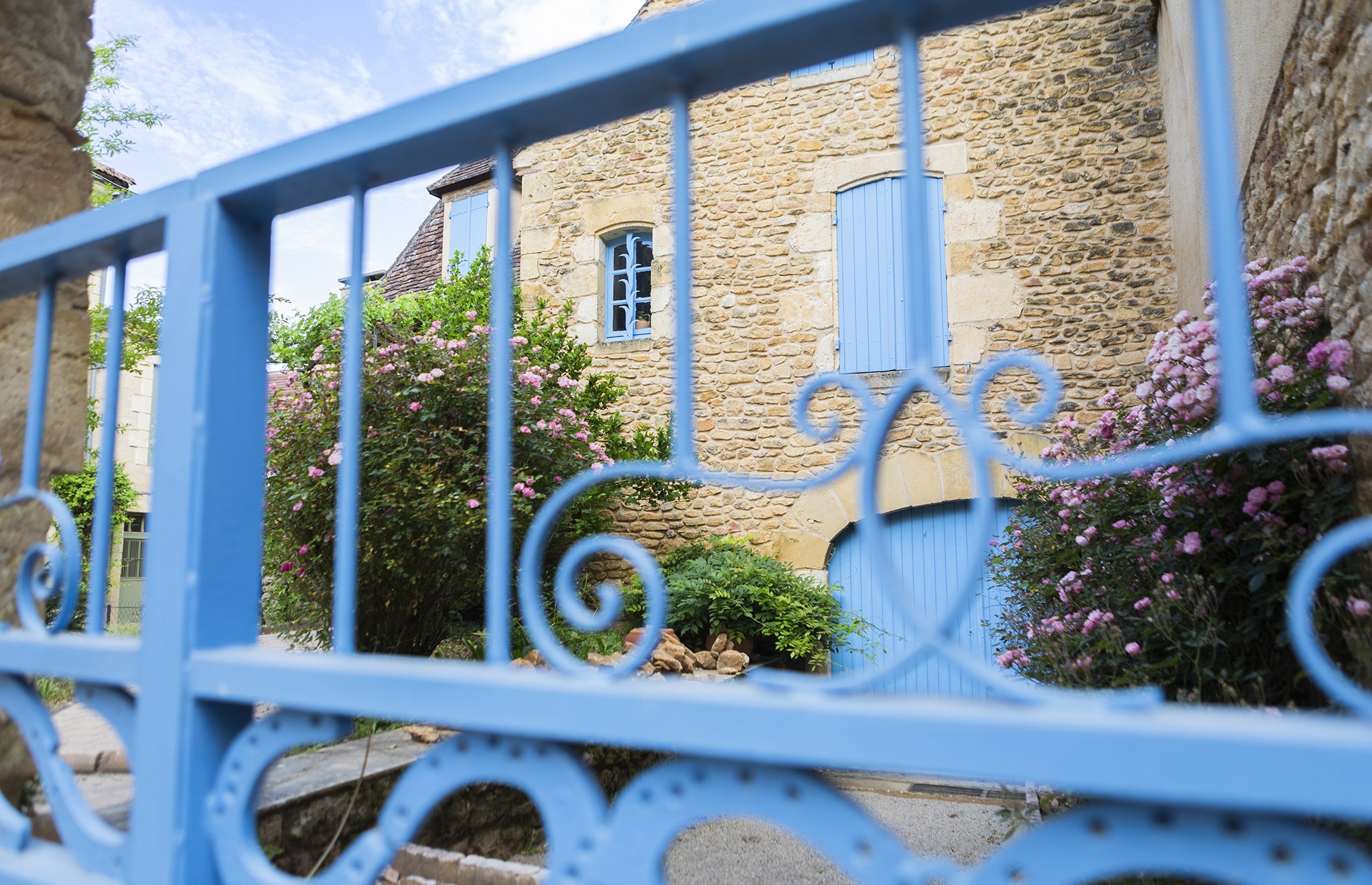 Blue gate in front of an old stone house